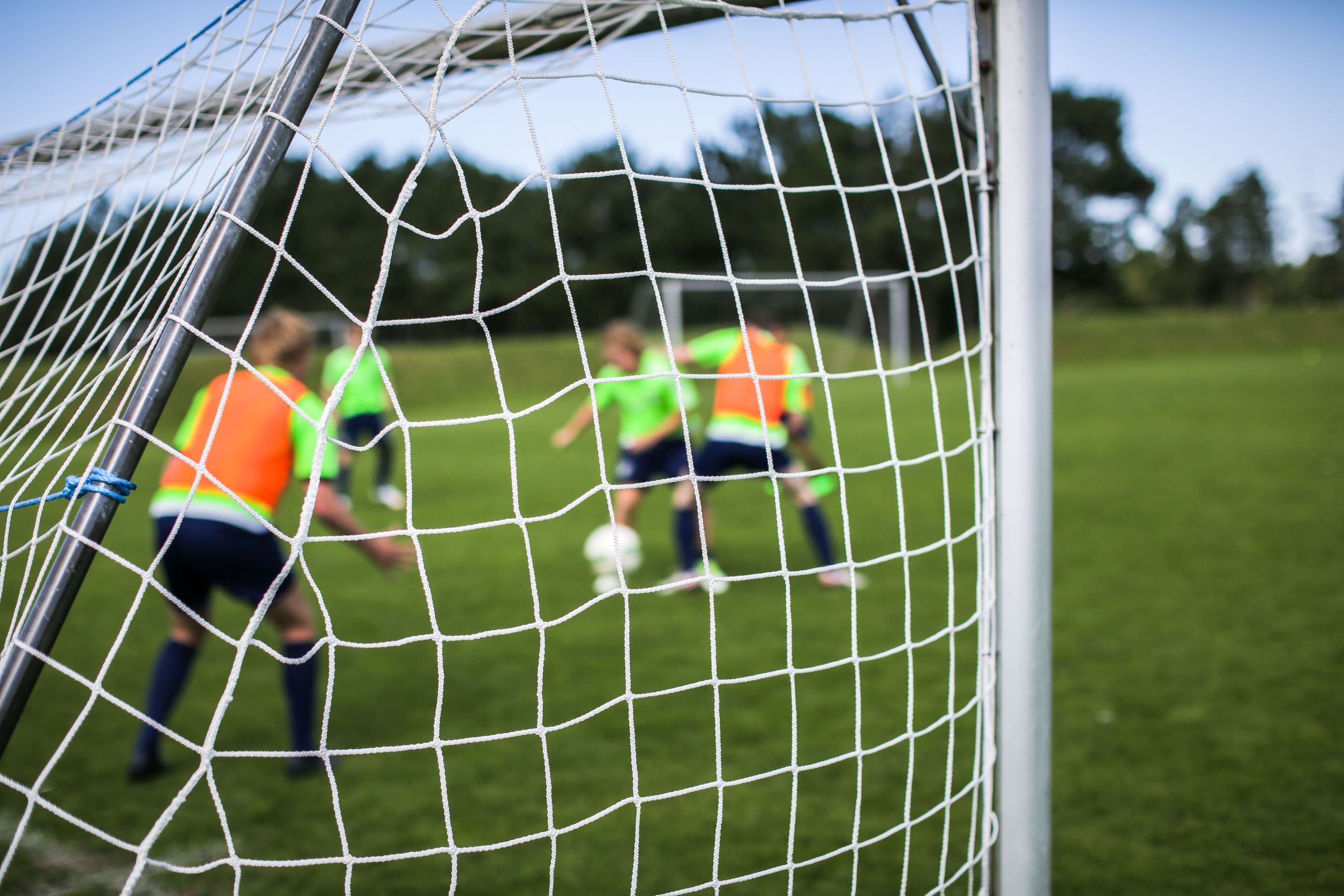 Man ser et fodboldnet og i baggrunden er der elever der spiller fodbold