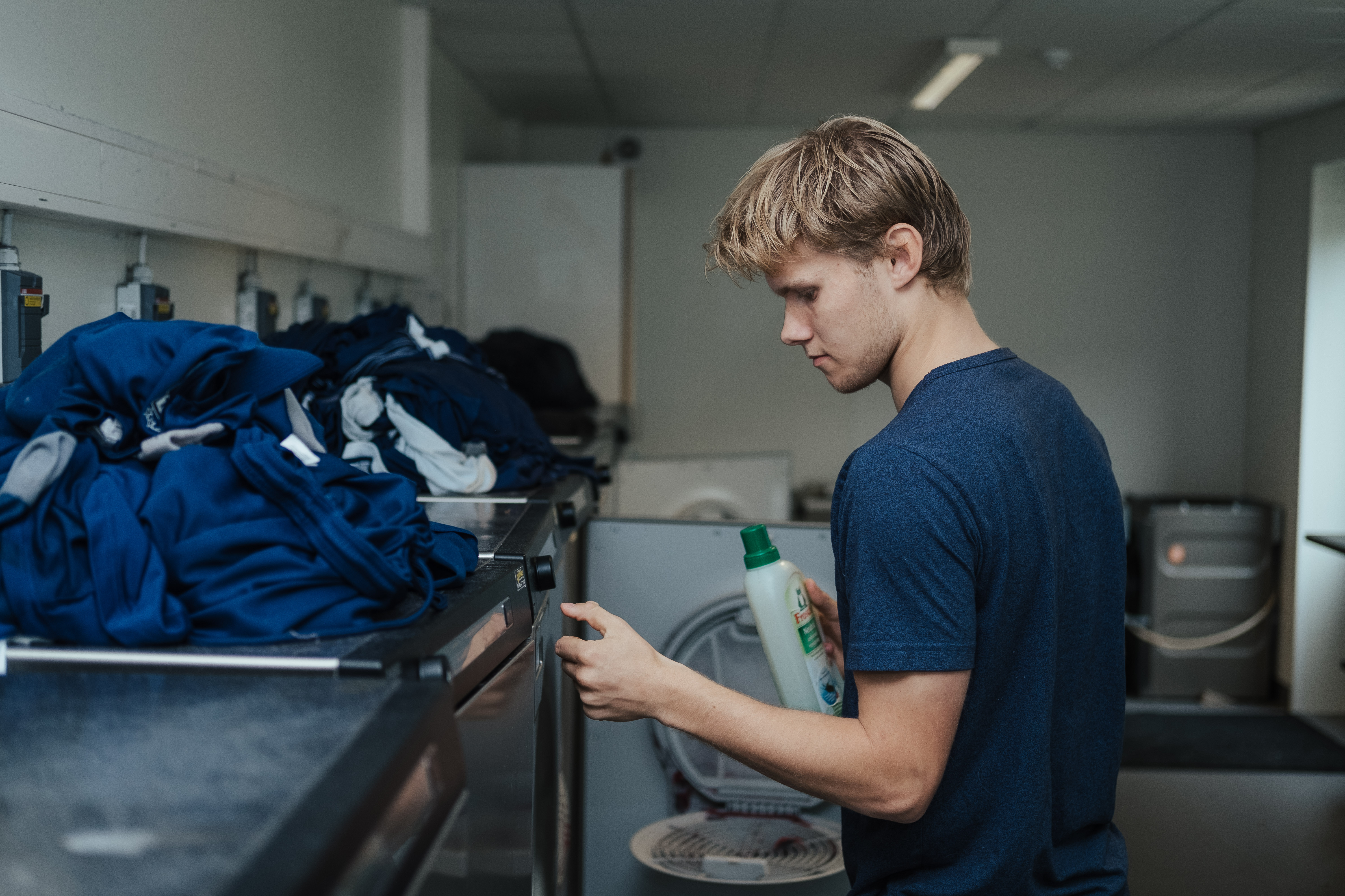 Christian Jensen er ved at fylde sæbe i en vaskemaskine